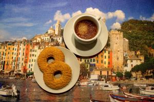 a cup of coffee and a donut on a plate at Immobiliare P&P - Arena House in Genova