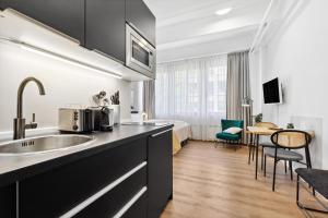 a kitchen with a sink and a room with a bed at Limehome Munich Fritz-Erler Str in Munich