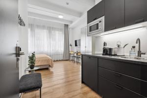 a kitchen with a sink and a room with a bed at limehome Munich Fritz-Erler Str in Munich