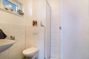 a white bathroom with a toilet and a sink at Ferienwohnung Inzigkofen in Inzigkofen