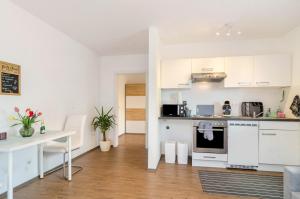 a kitchen with white cabinets and a white table at Ferienwohnung Inzigkofen in Inzigkofen