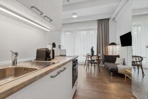 a kitchen with a sink and a living room at Limehome Munich Fritz-Erler Str in Munich