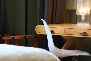 a white chair sitting next to a wooden desk at Le Sens Six in Montpellier