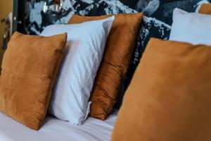 una pila de almohadas en una cama con almohadas marrones en Le Sens Six en Montpellier