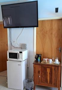 a microwave sitting on top of a refrigerator with a tv at The Golden Grape B&B in Lutzville