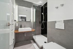 La salle de bains est pourvue d'un lavabo et d'une douche. dans l'établissement limehome Munich Fritz-Erler Str, à Munich