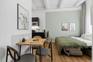 a bedroom with a bed and a table and chairs at Limehome Munich Fritz-Erler Str in Munich