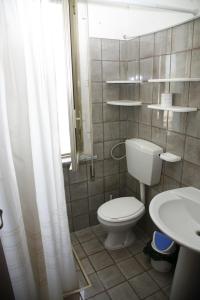 a bathroom with a white toilet and a sink at Tre Fontane sul Mare in Tre Fontane