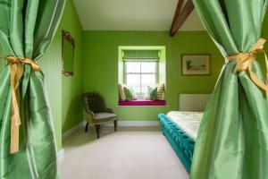 1 dormitorio con paredes verdes, 1 cama y ventana en Lowtown Cottage en Brampton