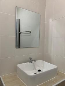 un lavandino bianco in un bagno con specchio di กิจตรงวิลล์ รีสอร์ท Kittrongvill a Ubon Ratchathani