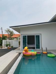 een zwembad met opblaasbaar speelgoed in een huis bij กิจตรงวิลล์ รีสอร์ท Kittrongvill in Ubon Ratchathani