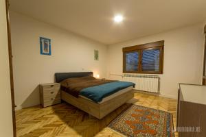 a bedroom with a bed and a dresser and a window at BB Sima in Bajina Bašta