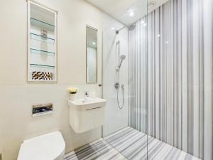 a bathroom with a shower and a toilet and a sink at Be London - Chancery Lane Apartments in London