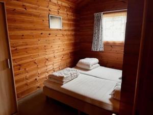 um quarto com uma cama num chalé de madeira em Sfeervolle en ruime chalet Il Mondo em Mauroux