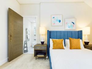 a bedroom with a blue bed with yellow pillows at Be London - Chancery Lane Apartments in London