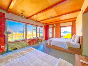 1 dormitorio con 2 camas y ventanas grandes en Cánh Buồm Homestay - Tuần Châu en Ha Long