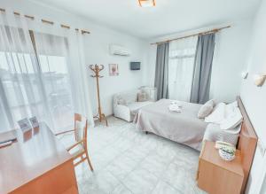 Un dormitorio blanco con una cama y un sofá. en Hotel Duc de Vendôme, en Vinarós