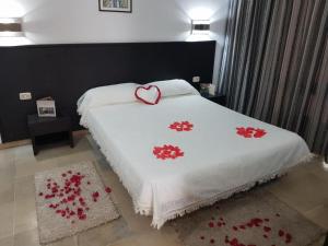 a bed with a white blanket with a heart on it at App S1 à l'hôtel Andalucia Beach in Bizerte