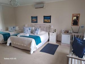 1 dormitorio con 2 camas y almohadas azules en The Golden Grape B&B en Lutzville