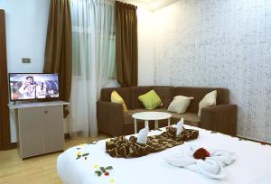 Habitación con cama, sofá y TV. en Riverland Hotel, en Bahir Dar
