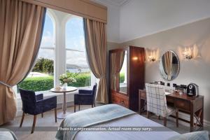 sypialnia z łóżkiem, biurkiem i oknem w obiekcie The Belsfield Hotel w mieście Bowness-on-Windermere