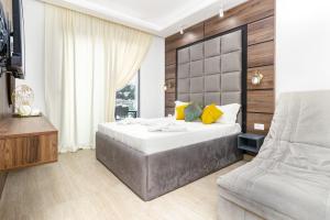 1 dormitorio con 1 cama grande y 1 silla en Prego Lux en Ulcinj