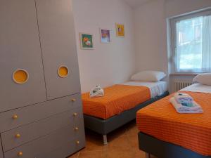 een slaapkamer met 2 aparte bedden en een dressoir bij Residence Kormorano Malcesine Apt 52 in Malcesine