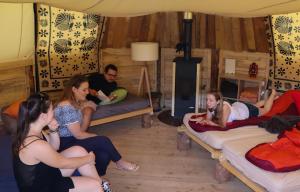 eine Gruppe von Personen, die in einem Zimmer auf Betten sitzen in der Unterkunft Village Tipi in La Feclaz