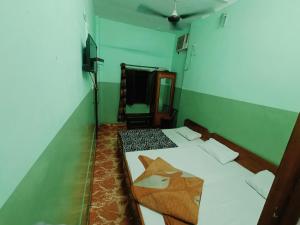 a room with two beds and a tv in it at Hotel Poojan Heritage in Haridwār