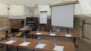 een grote kamer met tafels met waterflessen bij Village Tipi in La Féclaz