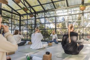 a group of people sitting in a yoga room looking out the window at Finca Serena Mallorca, Small Luxury Hotels in Montuiri