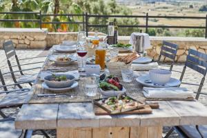 a wooden table with plates of food on it at Finca Serena Mallorca, Small Luxury Hotels in Montuiri