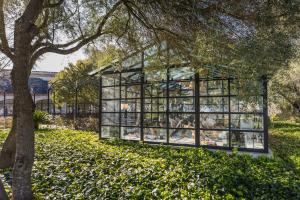 a glass house in a park with a tree at Finca Serena Mallorca, Small Luxury Hotels in Montuiri