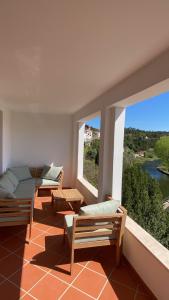 sala de estar con 2 sillas y 2 ventanas en Mira D'Ouro Serta, en Sertã