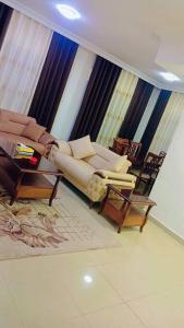 sala de estar con sofá y 2 sillas en شقة فاخرة واسعة في شارع المدينة المنورة, en Umm Uthainah