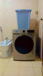 a bathroom with a toilet and a microwave and a sink at شقة فاخرة واسعة في شارع المدينة المنورة in Umm Uthainah