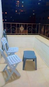 two chairs and a stool sitting on a balcony at شقة فاخرة واسعة في شارع المدينة المنورة in Umm Uthainah