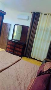 a bedroom with a mirror and a bed and a dresser at شقة فاخرة واسعة في شارع المدينة المنورة in Umm Uthainah
