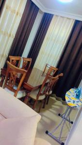 two chairs and a bed in a room with curtains at شقة فاخرة واسعة في شارع المدينة المنورة in Umm Uthainah