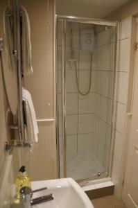 La salle de bains est pourvue d'une douche et d'un lavabo. dans l'établissement Radcliffe Guest House, à Ross-on-Wye