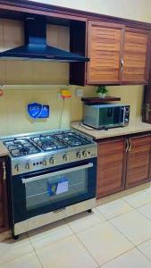 a kitchen with a stove and a microwave at شقة فاخرة واسعة في شارع المدينة المنورة in Umm Uthainah