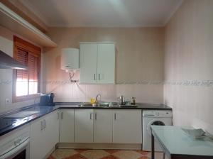 a kitchen with white cabinets and a sink at Apartamento completo en Sierra Sur in Villanueva de San Juan