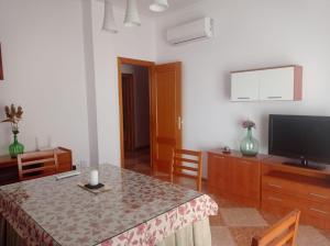 a living room with a table and a flat screen tv at Apartamento completo en Sierra Sur in Villanueva de San Juan