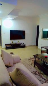 a living room with a couch and a tv at شقة فاخرة واسعة في شارع المدينة المنورة in Umm Uthainah
