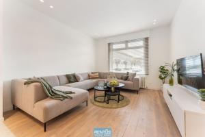 sala de estar con sofá y mesa en Casa Diva – renovated house for 12 in Blankenberge en Blankenberge