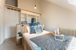 een slaapkamer met een groot bed met blauwe kussens bij Casa Diva – renovated house for 12 in Blankenberge in Blankenberge