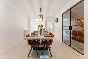 een eetkamer met een lange tafel en stoelen bij Casa Diva – renovated house for 12 in Blankenberge in Blankenberge