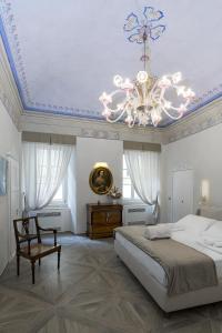 a bedroom with a large bed and a chandelier at La Casa del Poeta in Colle Val D'Elsa
