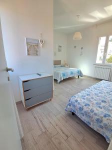 a bedroom with two beds and a dresser in it at Il Giardino in Riotorto