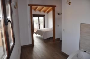 a bedroom with a bed and a door leading to a bathroom at La Costurera in Navatalgordo
